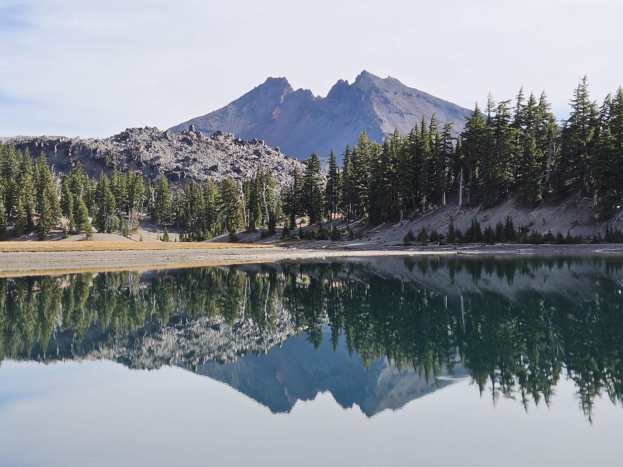 Broken Top reflected in the still water of Moraine Lake in Central Oregon's Three Sisters Wilderness.